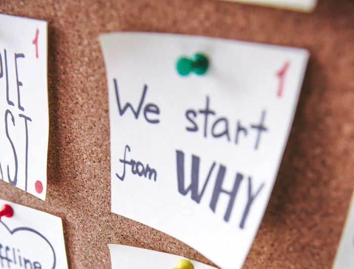 Close-up of motivational sticky notes with messages on a cork board.